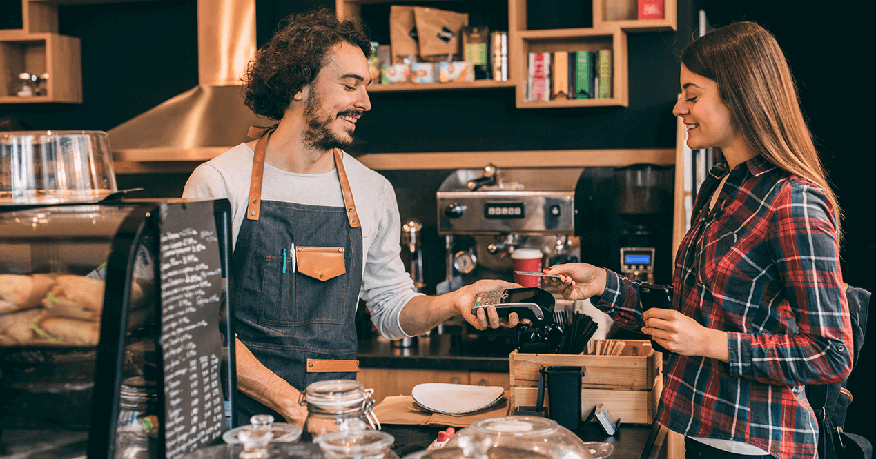 Kundin zahlt im Café mit Karte